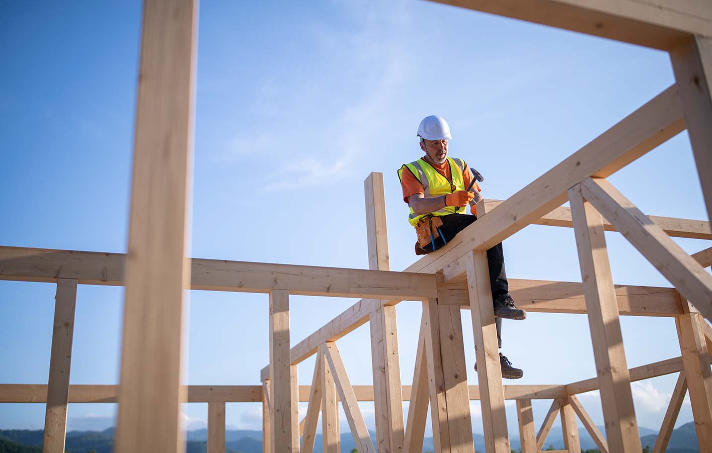 Holzbau - Konstruktionsholz mit einem Bauarbeiter.